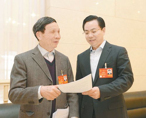 黃伯云代表（左）與劉國忠代表商討完善《關(guān)于建立戰(zhàn)略性新興產(chǎn)業(yè)國家創(chuàng)新平臺》的建議。 本報記者 張目 攝